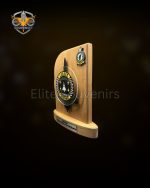 Wooden Commemorative Desk Plaque This wooden display plaque is built for official military and corporate presentations. The item features a solid light wood backboard mounted on a stable wooden base. It includes custom metal emblems and an engraving plate for specific event details. A matching presentation box accompanies the plaque for formal gifting. Product Specifications Build: Solid wood base and main board integrated with custom metal attachments. Detailing: Large central 3D metal crest and a secondary badge on the top right corner. Text Plate: Dedicated metal plate at the base for personalized text, names, and dates. Packaging: Secure presentation box featuring a custom logo on the lid to match the plaque design. Custom Production Details Wooden plaques with integrated metal badges are standard requirements for unit milestones, retirements, and corporate awards. The combination of custom wood shaping, detailed metal casting, and branded packaging highlights the manufacturing capacity available for specialized institutional orders. We produce these commemorative items according to exact unit and corporate specifications.